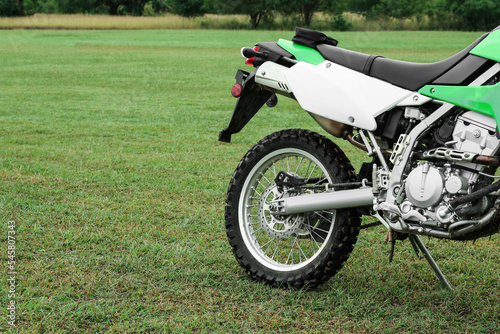 Stylish green cross motorcycle outdoors, space for text