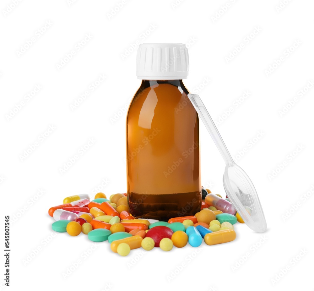 Bottle of syrup, plastic spoon with pills on white background. Cough and cold medicine Bottle of syrup, plastic spoon with pills on white background. Cough and cold medicine