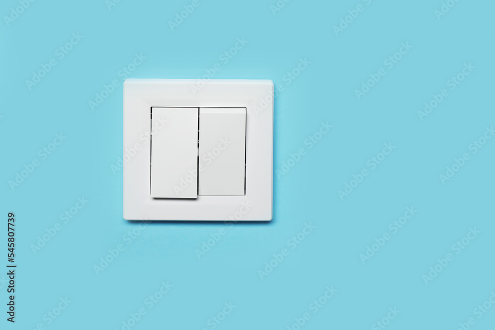 Modern plastic light switch on blue wall, space for text Modern plastic light switch on blue wall, space for text