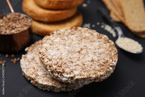 Rice cakes and rusks on black table, closeup