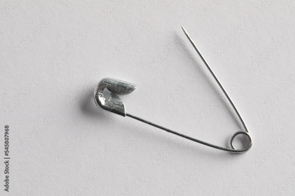Metal safety pin on white background, top view Metal safety pin on white background, top view