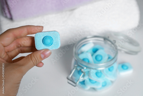 Woman holding water softener tablet, closeup view