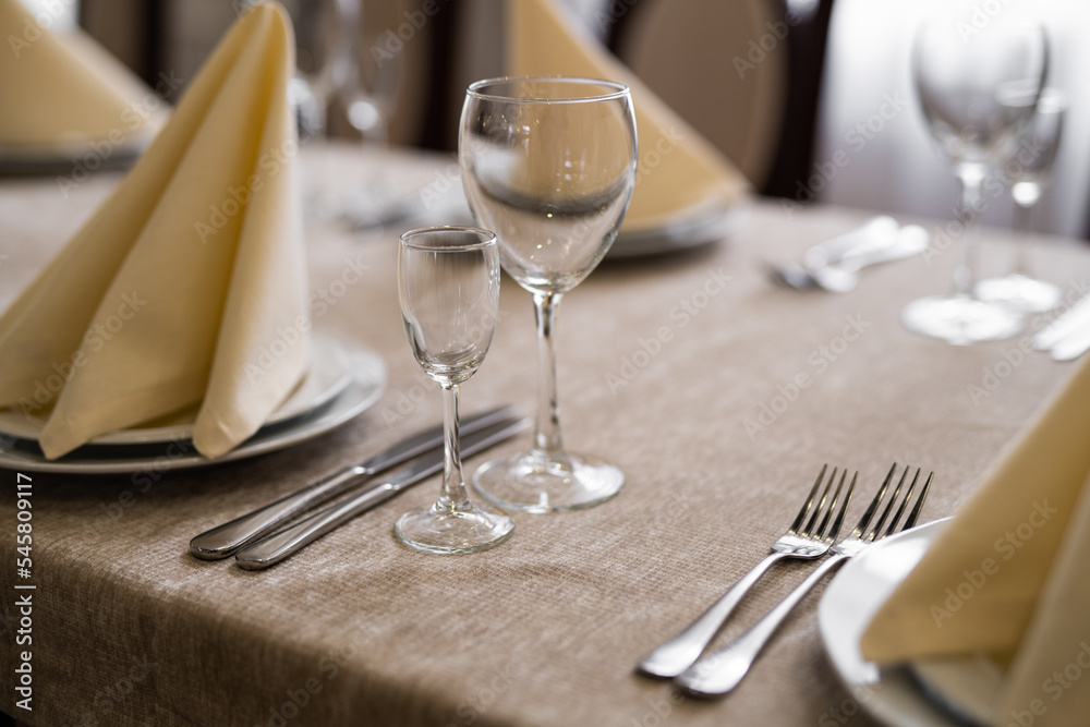 empty goblets and other cutlery are served on the festive table. empty goblets and other cutlery are served on the festive table.