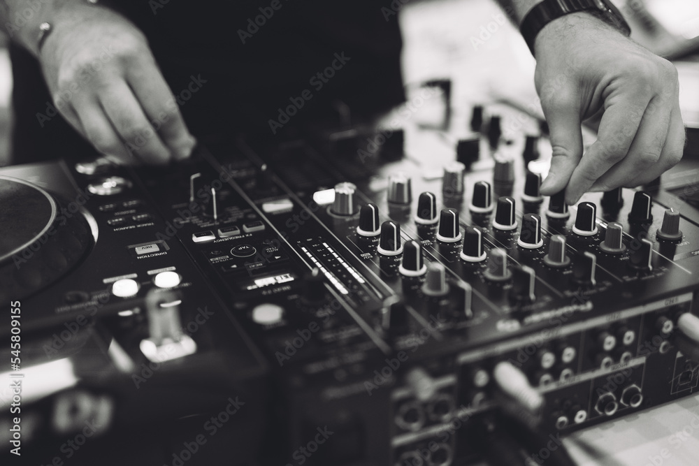 a DJ plays music on a controller at a party. a DJ plays music on a controller at a party.