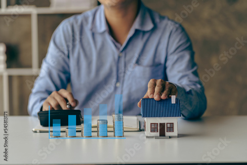 Check list before buying a new home to meet the bank criteria. Close-up shot of silver coin drop and house model Savings by adding your money to the real estate owner in a futuristic concept. photo