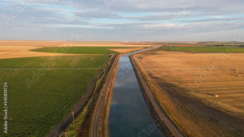 Drone view during sunrise over a farm hay field and river in Alberta Canada