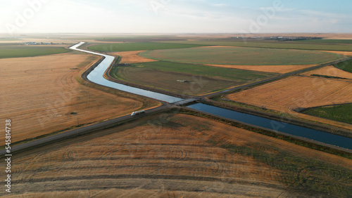 Drone view during sunrise over a farm hay field and river in Alberta Canada