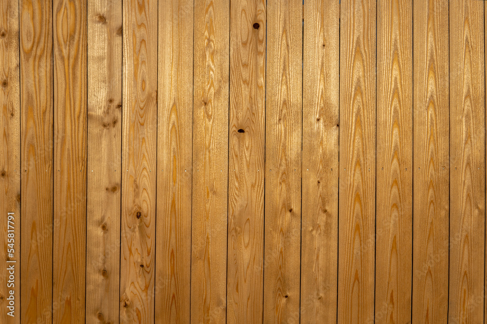 Vertical wooden yellow bars background. Texture of the pine boards lie vertically. Wood background Vertical wooden yellow bars background. Texture of the pine boards lie vertically. Wood background