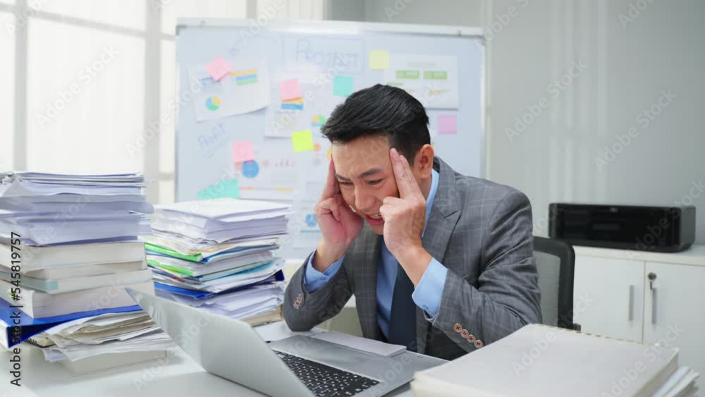 Exhausted Asian young businessman worker working on table in office. Exhausted Asian young businessman worker working on table in office.