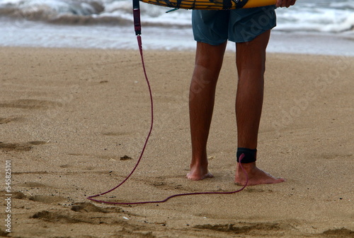 A man walks barefoot on the sand by the sea