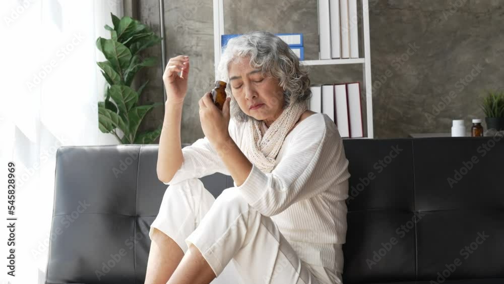 Sad depressed middle aged woman at home sitting on the couch, looking down and touching her forehead, loneliness and pain concept. Sad depressed middle aged woman at home sitting on the couch, looking down and touching her forehead, loneliness and pain concept.