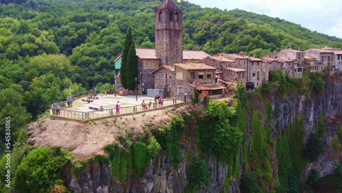 Flying away from a church, and the view point in Castellfollit de la Roca, typical village in Catalonia, Spain photo
