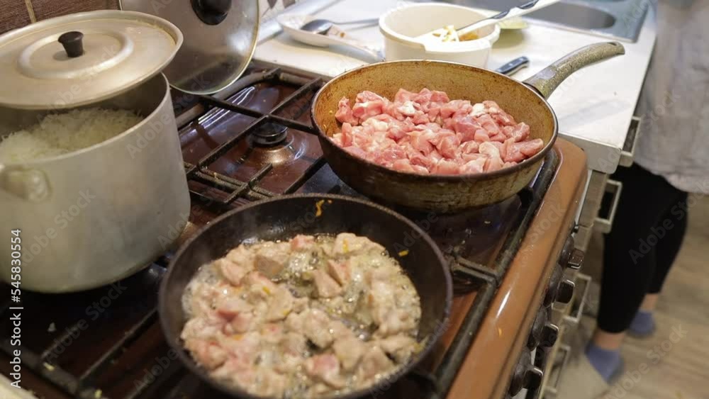 fry meat in a frying pan in the kitchen fry meat in a frying pan in the kitchen