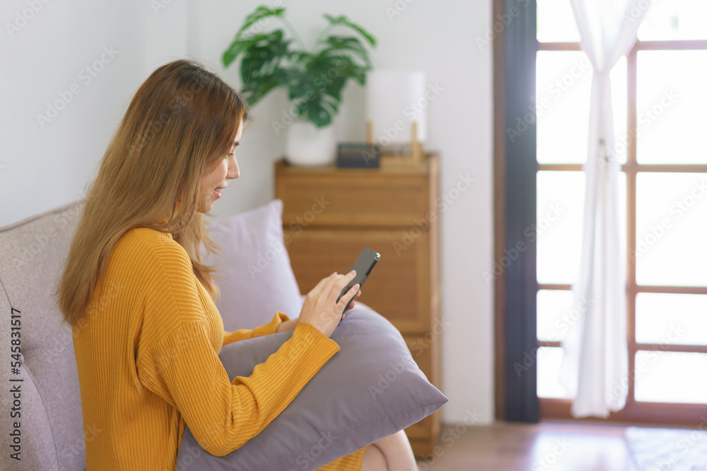 Work from home concept, Asian woman use smartphone to surfing internet after successfully work Work from home concept, Asian woman use smartphone to surfing internet after successfully work