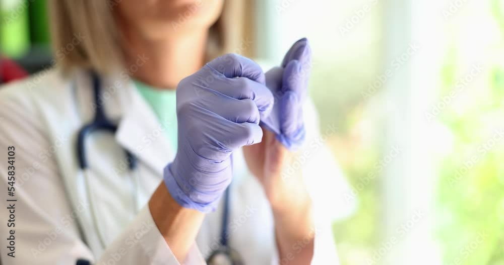 Doctor removes disposable medical gloves in clinic Doctor removes disposable medical gloves in clinic