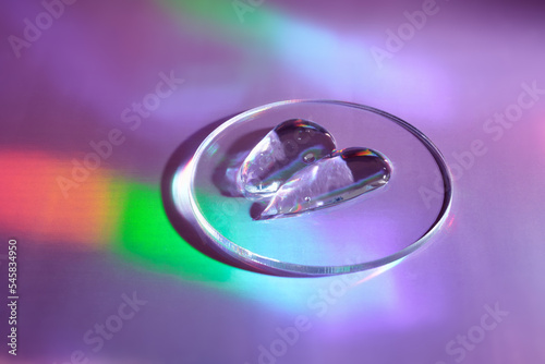 Smear of gel cosmetics product in petri dish on holographic background with iridescent highlights