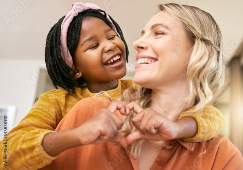 Heart sign, adoption and mother with black girl, happy together for bonding, loving and smile. Love, foster mother and daughter being cheerful, happiness and joyful to celebrate adopted child in home photo