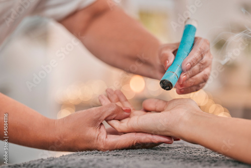 Spa  wellness and moxibustion treatment for hand in salon with alternative healing  natural medicine and therapy. Healthcare  luxury and massage therapist using smoke stick for stress relief in body