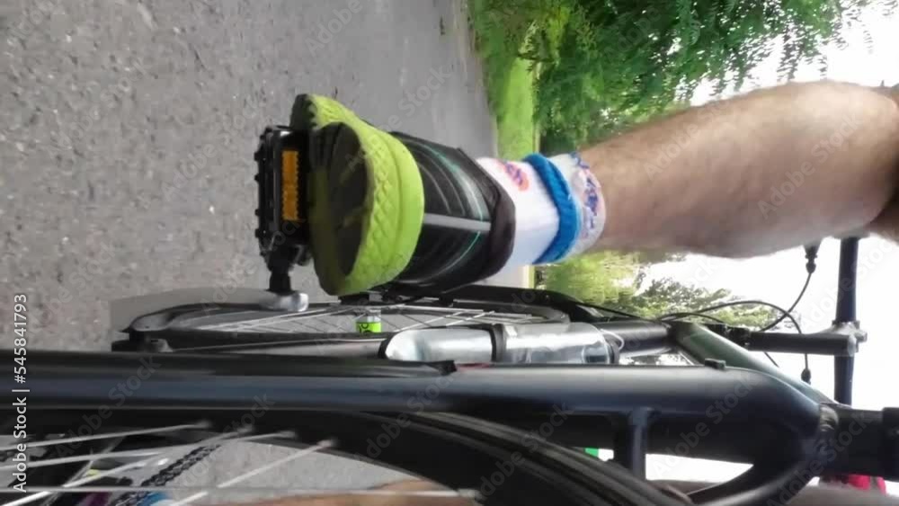 Legs of a man who rides a bicycle. Low angle of view Legs of a man who rides a bicycle. Low angle of view