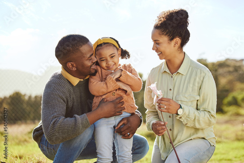 Happy family, hug and nature with a mother, father and girl on an outdoor adventure in a green park. Black family, smile and travel of a mom, man and child bonding on a countryside field in spring
