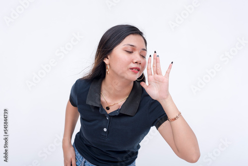 A young devious woman looking to share the latest gossip. Gesturing with her hand while leaning forward to seduce someone. Isolated on a white background.