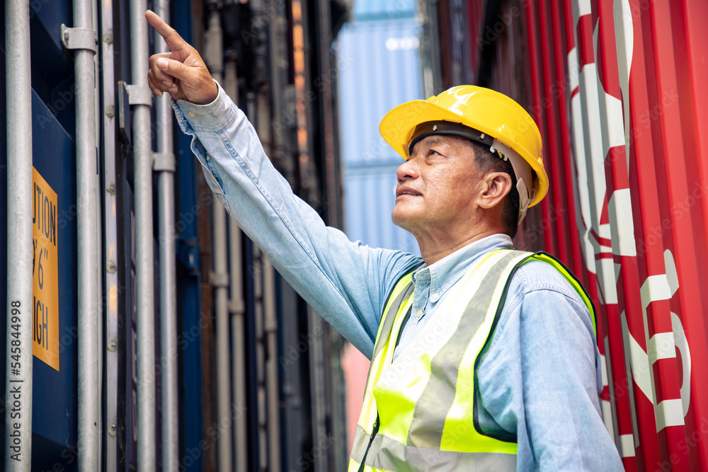 Asian senior engineer man worker checking shipment at containers store. Manage the export of goods to foreign countries, Lagre cargo shipment Asian senior engineer man worker checking shipment at containers store. Manage the export of goods to foreign countries, Lagre cargo shipment