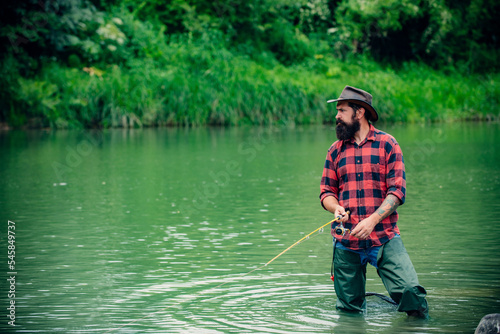 Fisherman man on river or lake with fishing rod.