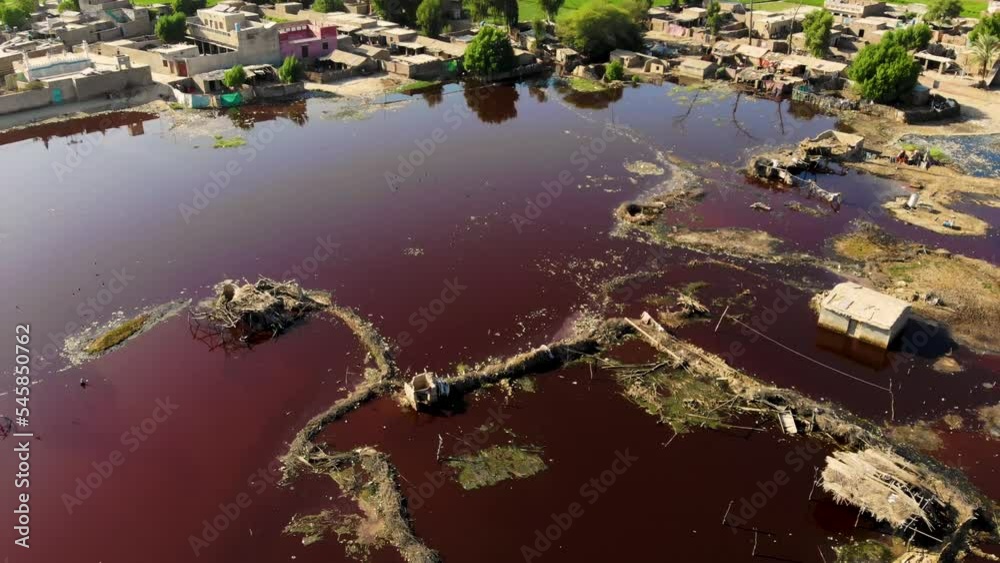 Aerial View Of Dark Red Stale Putrid Floodwaters In Daharki. Dolly Back, Tilt Up Aerial View Of Dark Red Stale Putrid Floodwaters In Daharki. Dolly Back, Tilt Up