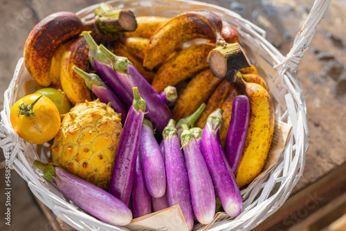 A basket of freshly harvested eggplant, banana, tomato and sweetsop, sugar-apple photo