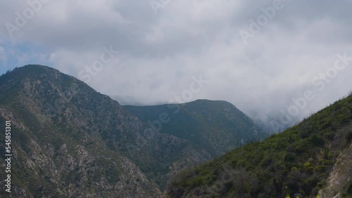 Time lapse of ravine with white clouds flying over them located in Echo Mountain Trails California. photo