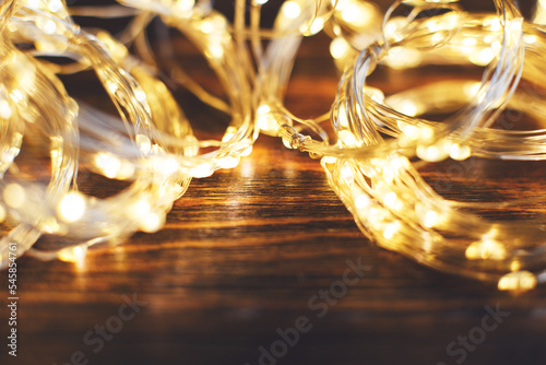 christmas beautifull shiny gold garland on a wooden brown background. sparkle festive background