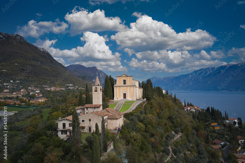 The parish church of San Michele Arcangelo is located on a hill overlooking Lake Garda, Italy. Panoramic aerial view of the Church of San Michele Arcangelo.