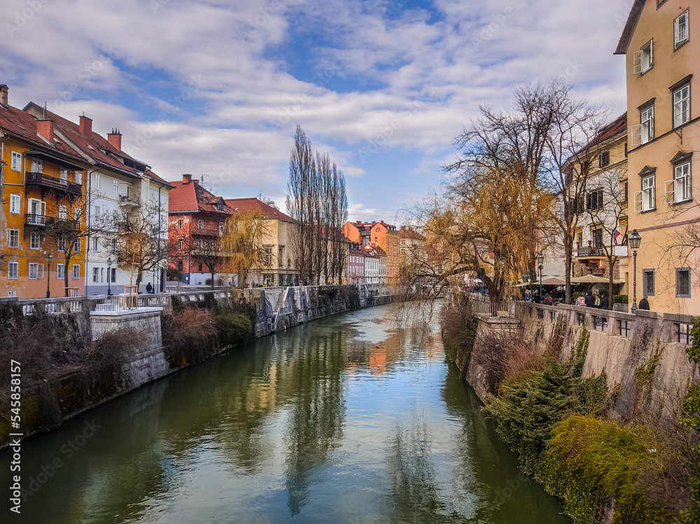 Naklejka premium Ljubljana, Slovenia - The old town of Ljubljana with Ljubljanica river and traditional Slovenian houses on a sunny winter day with blue sky and clouds