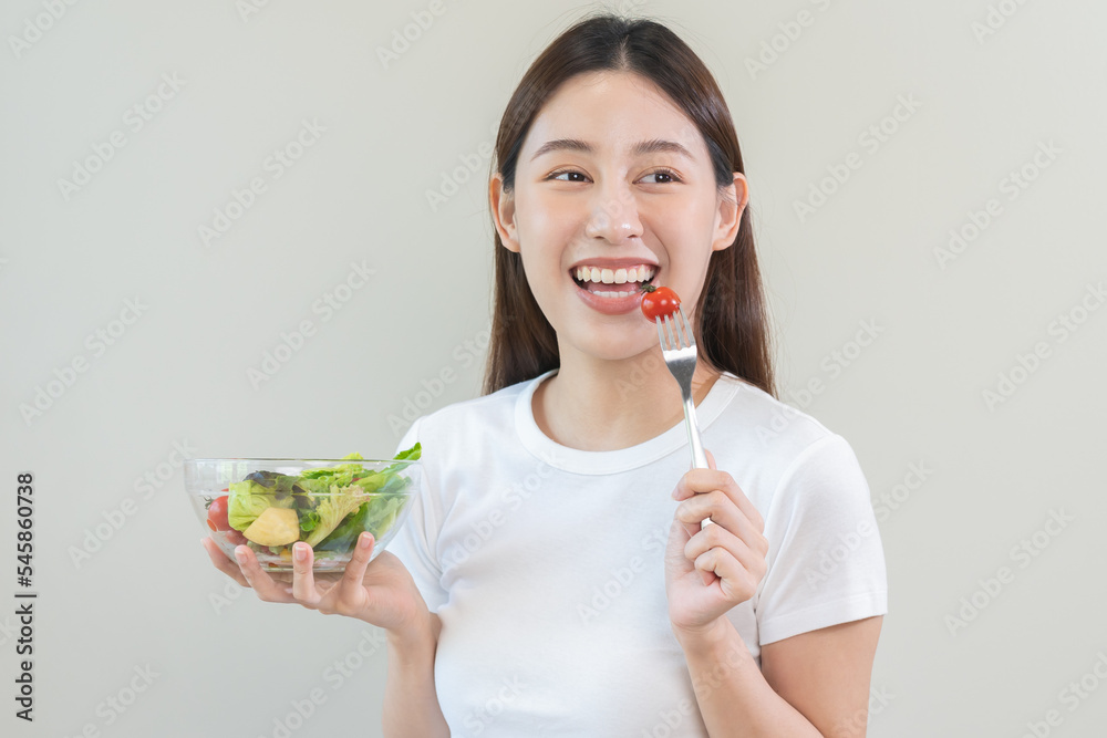 Diet, Dieting asian young woman or girl use fork at tomato on mix vegetables, green salad bowl, eat food is low fat good health. Nutritionist female, Weight loss for healthy person. Diet, Dieting asian young woman or girl use fork at tomato on mix vegetables, green salad bowl, eat food is low fat good health. Nutritionist female, Weight loss for healthy person.