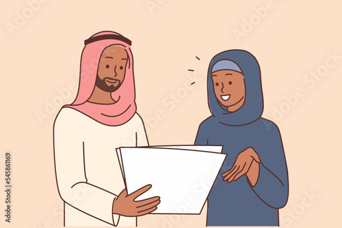 Smiling Arabic businesspeople discuss paperwork 