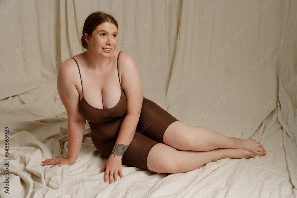 White young woman smiling and posing while sitting on floor White young woman smiling and posing while sitting on floor