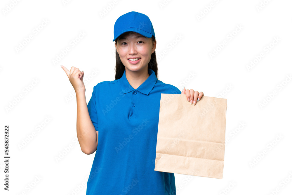 Young Asian woman taking a bag of takeaway food over isolated background pointing finger to the side