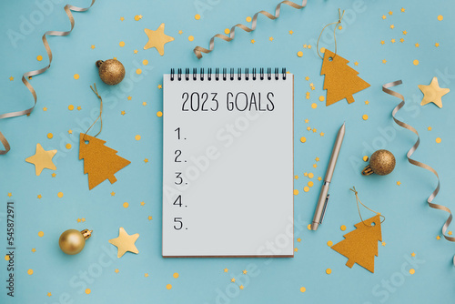 New Year goals List 2021 with notebook written in handwriting about plan listing of new year goals and resolutions setting. flat lay style. Christmas planning concept. photo