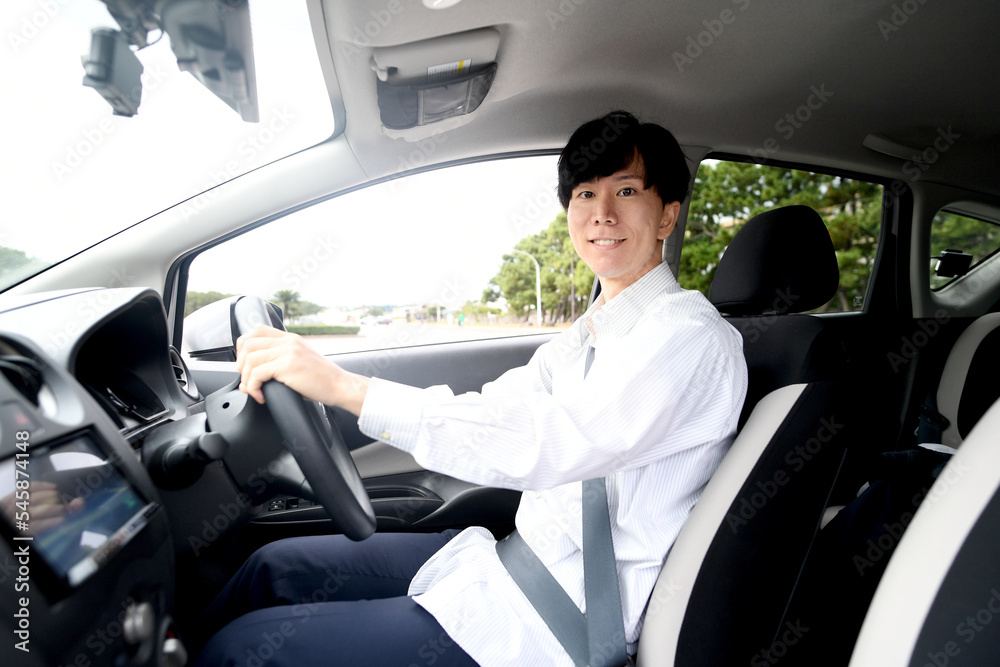 笑顔で運転をする若いアジア人男性