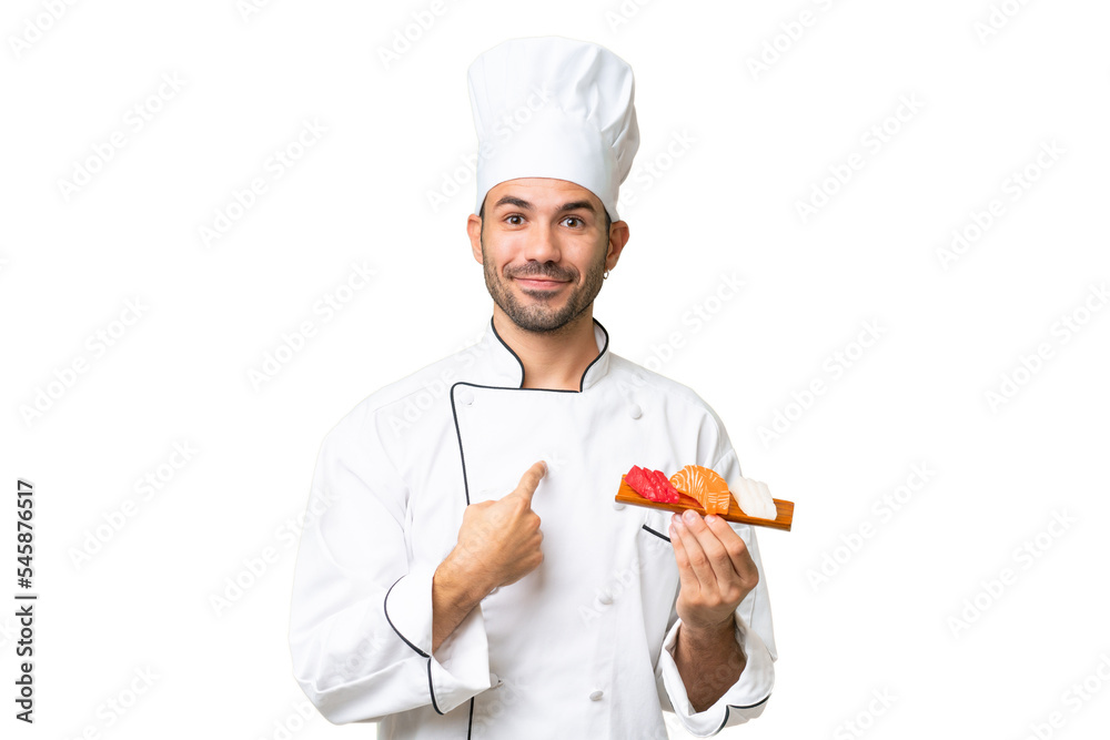 Young caucasian chef holding a sushi over isolated background with surprise facial expression Young caucasian chef holding a sushi over isolated background with surprise facial expression