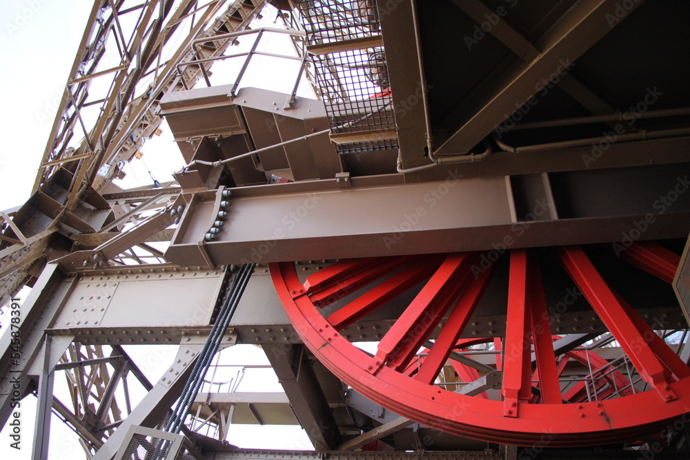 details of the red cogwheel of the metal construction of the eiffel tower