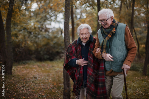 Senior couple walking together in autumn forest. © Halfpoint