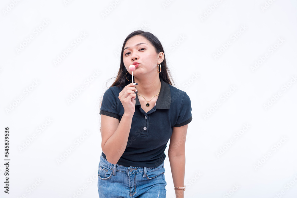 A nice asian woman teasing with a lollipop. Isolated on a white background. A nice asian woman teasing with a lollipop. Isolated on a white background.
