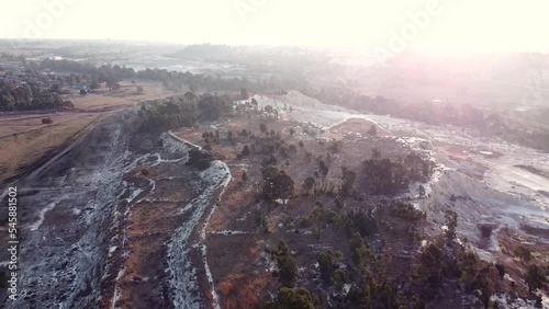 Aerial drone shot tracking backwards over an old abandoned mine dump during sunrise on a beautiful day, Benoni, South Africa  photo