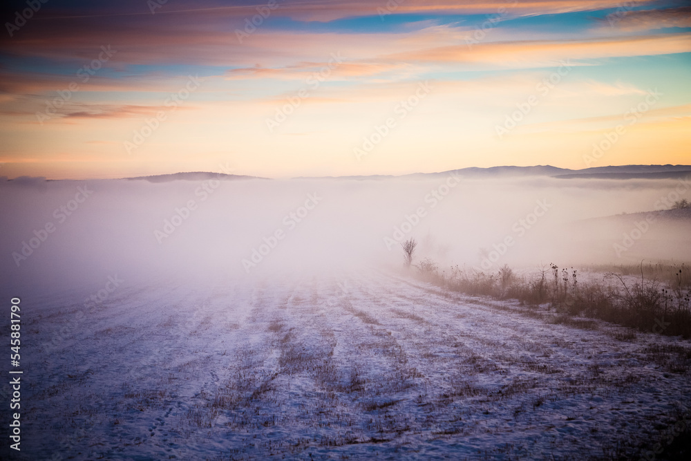 moody winter landscape with fog at sunset moody winter landscape with fog at sunset
