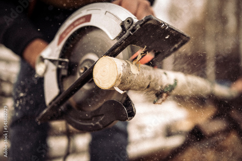 Hands of man sawing wood log photo