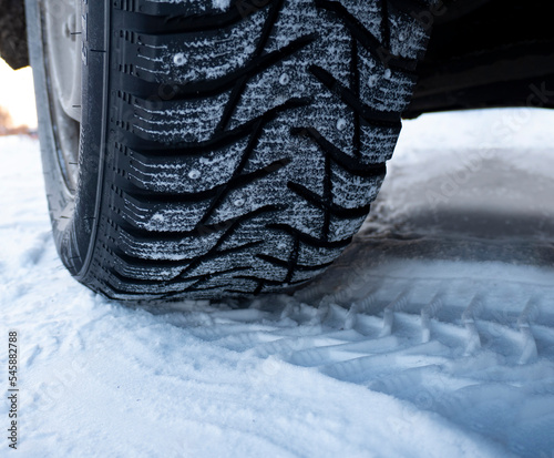 Car tires on winter road covered with snow, Closeup © Chepko Danil
