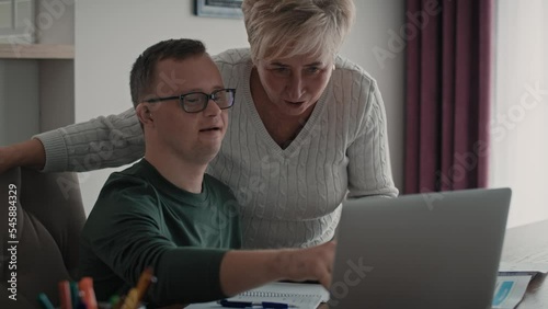 Caucasian man with down syndrome learning with his mum at home. Shot with RED helium camera in 8K.    