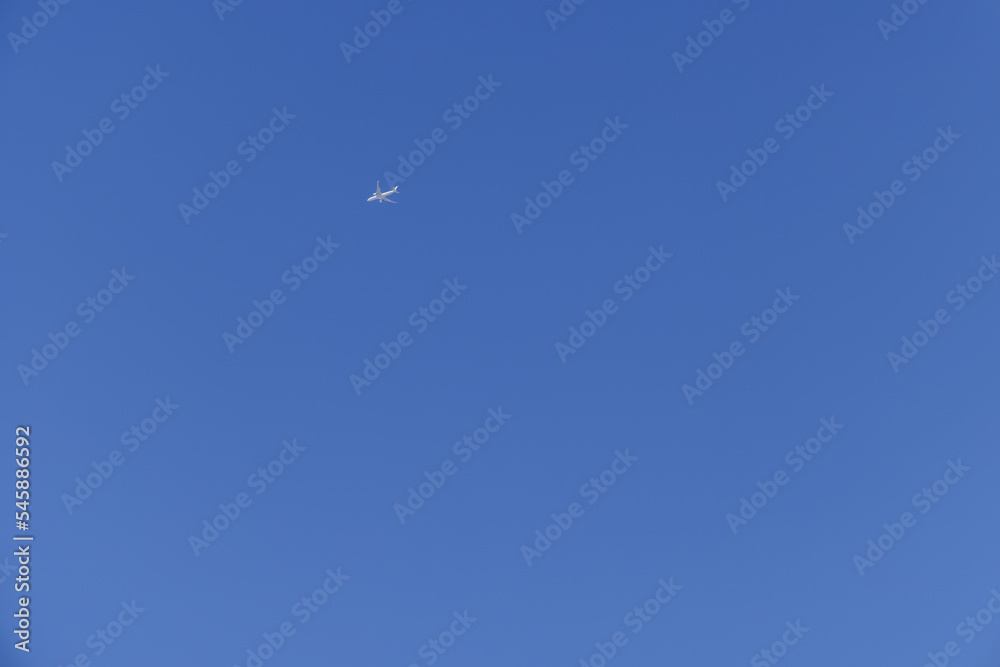 青空を飛ぶ白いジェット旅客機
