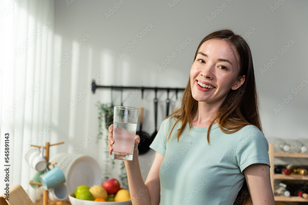 Portrait of Caucasian woman drink a glass of water in kitchen at home. Portrait of Caucasian woman drink a glass of water in kitchen at home.